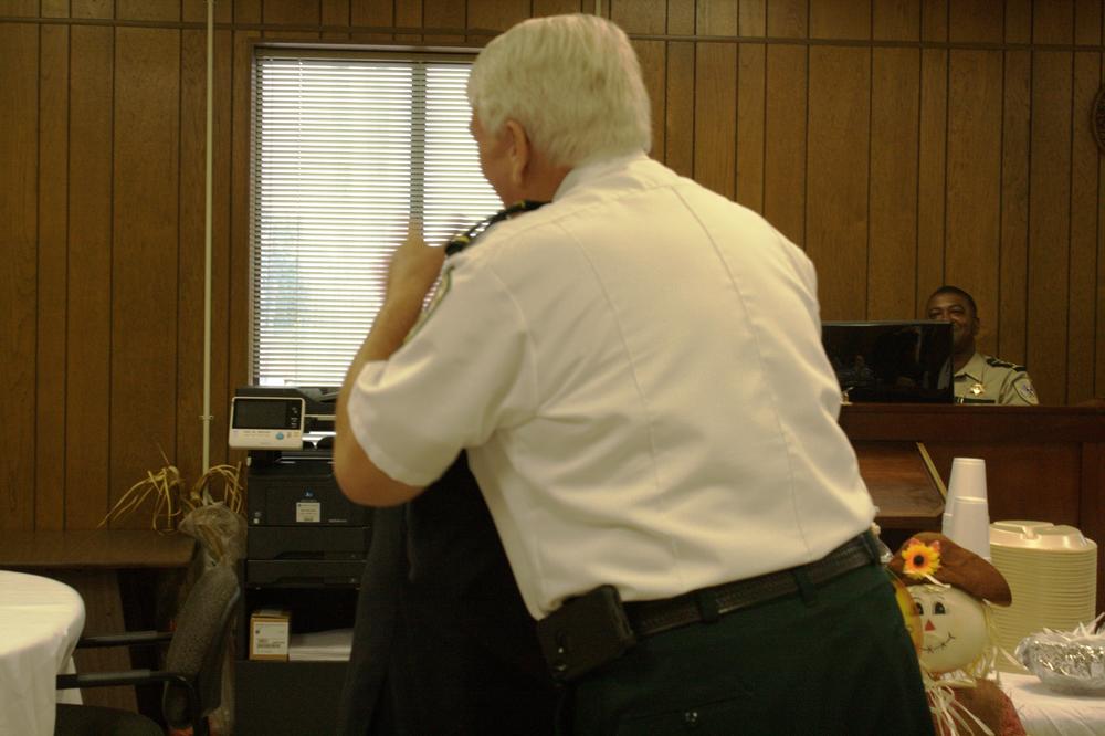 Officer walking by a table.