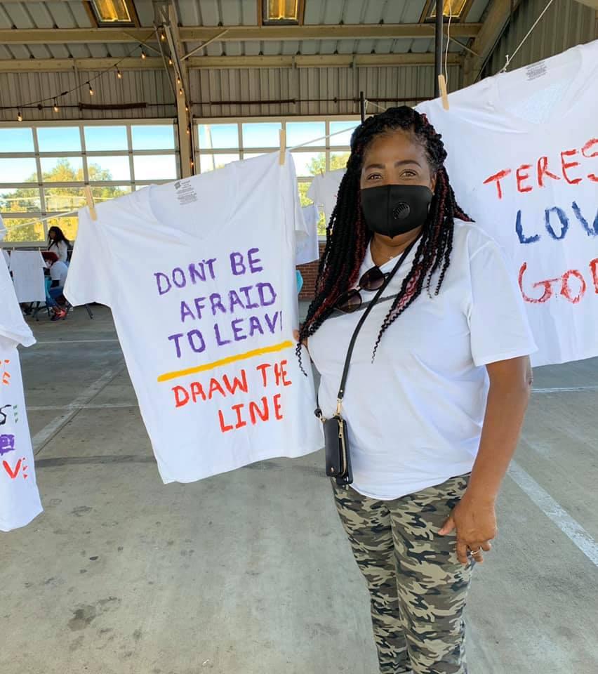 volunteer Pearlie Guice poses with tshirt she designed.